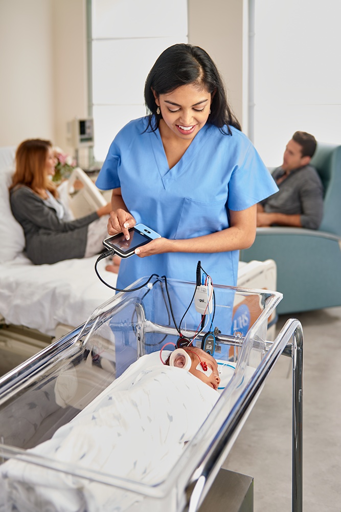 Profesional de salud evaluando a un recién nacido en su cuna con el GSI Novus